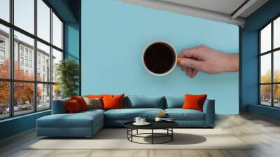 Hand holding coffee cup on bright pink background Wall mural