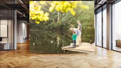 Boy, father and grandfather fishing in lake Wall mural