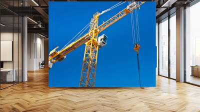 yellow crane against blue sky Wall mural