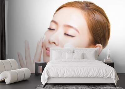 beautiful young woman applying cosmetic cream  on her face Wall mural