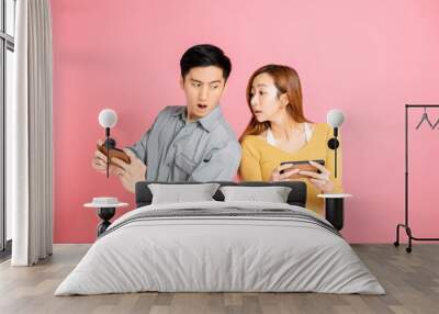 Cheerful young couple watching and playing the smart phone Wall mural