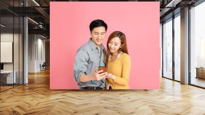 Cheerful young couple watching  the smart phone Wall mural