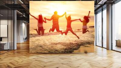 group of happy young people jumping on the beach Wall mural