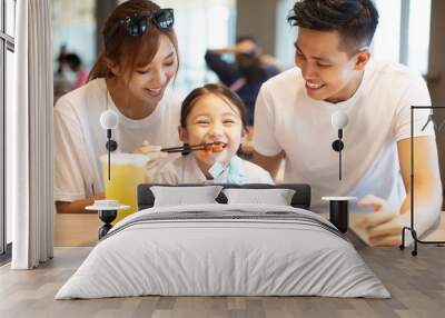 Happy family  enjoying dinner in restaurant. Wall mural