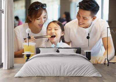 Happy family  enjoying dinner in restaurant. Wall mural