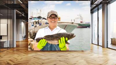 happy fisherman showing  fish before fishing ship Wall mural