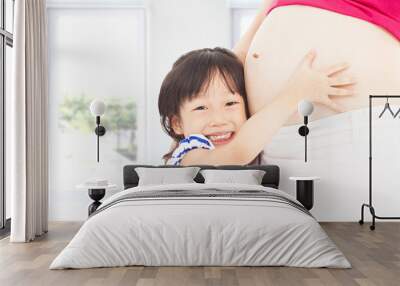 happy  little girl hugging a pregnant mother's belly Wall mural