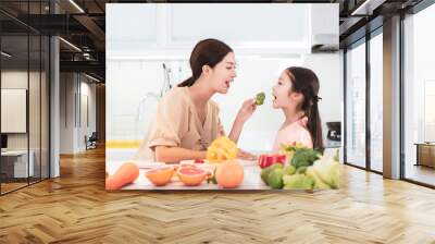 happy Mother and child daughter  preparing and eating the vegetables and fruit Wall mural