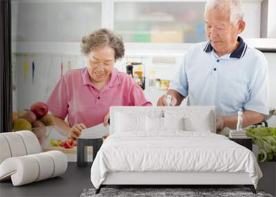 happy senior couple cooking in kitchen Wall mural