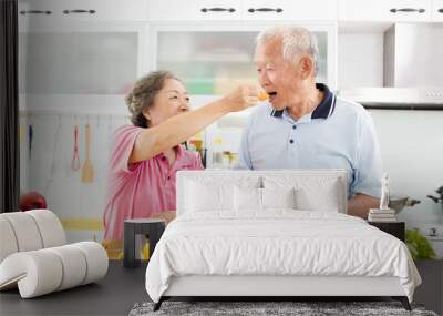 happy senior couple cooking in kitchen Wall mural