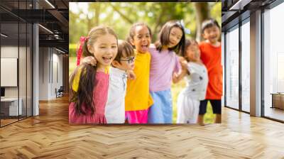 Multi-ethnic group of school children laughing and embracing Wall mural