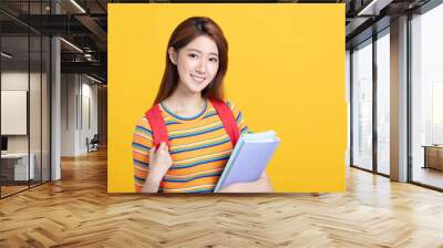 Portrait of beautiful asian young student holding books Wall mural