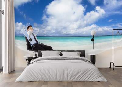 relaxed Young businessman sitting in  chair with beach backgrou Wall mural