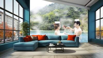 Young asian couple relaxing in hot springs Wall mural