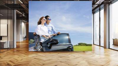 young couple standing near the car and enjoy summer vacation Wall mural