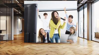 young woman holding microphone and singing at karaoke. Wall mural