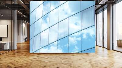 Contemporary office building with reflective glass panels that mirror blue sky and white clouds, building blending with the sky. Modern minimalistic corporate architecture, simple background texture Wall mural