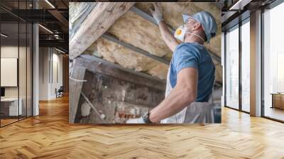 Caucasian Contractor Worker in His 30s Replacing Old Attic Mineral Wool Insulation. Wearing Safe Breath Pro Mask. Industrial Home Improvement and Insulation Materials Theme. Wall mural