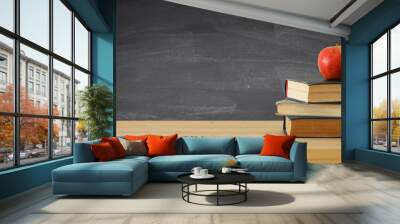 back to school banner. stack of books over wooden desk in front of blackboard. Wall mural