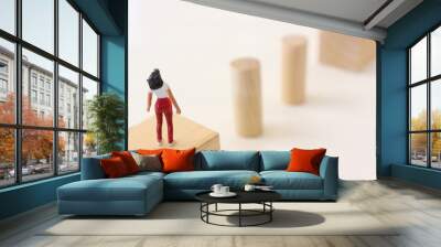 Concept image of a woman who needs to cross to the other side, by jumping over obstacles Wall mural