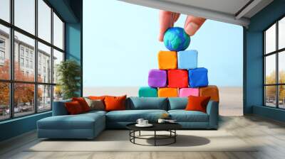 Concept image stack of colorful cubes and globe over wooden table Wall mural