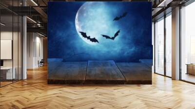 Halloween holiday concept. Empty rustic table in front of scary and misty night sky with black bats and full moon background. Ready for product display montage. Wall mural