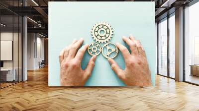 hand placing a cogwheel in set of gears mechanism Wall mural