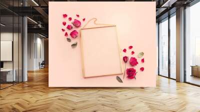 top view of dry rose flower and gold elegant empty frame over pink pastel background. For mock up, copy space Wall mural