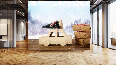 Wooden car carrying a christmas tree in front of abstract landsc Wall mural