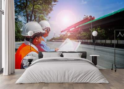 Male Engineer  looking at constructions site map . Construction site engineer in safety vest and hard hat. Wall mural