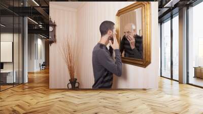 young man looking at an older himself in the mirror Wall mural