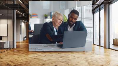 Diverse colleagues sitting at desk and discussing strategy of new startup project Wall mural