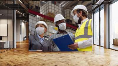 Diverse warehouse inspectors wearing safety mask discussing distribution plan on clipboard Wall mural