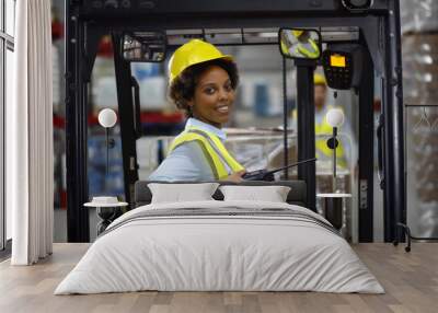 Female african forklift driver working in warehouse Wall mural