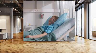 Sick kid with nasal oxygen tube lying in hospital bed  Wall mural