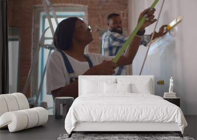 Side view of afro-american couple doing house renovation together Wall mural