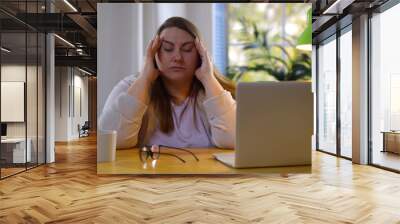 Tired fat woman suffering eyestrain working on laptop at home Wall mural