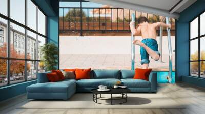 Kid having fun near the swimming pool in the resort, orange and teal vibe. cypres, children Wall mural