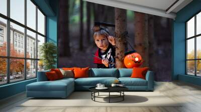 Boy in a forest with Halloween costumes, carved pumpkins with candles and decoration, creepy concept Wall mural