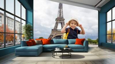 Happy blond toddler child, boy, visiting Paris during the summer, standing in front of the Eiffel tower Wall mural