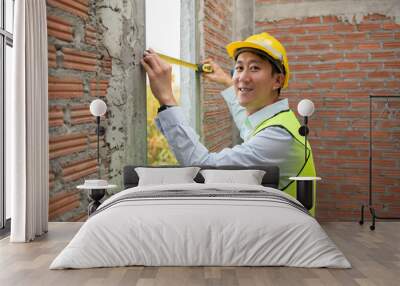 An Asian Engineering man wearing safety helmet checking construction site analyzing about project progress Wall mural