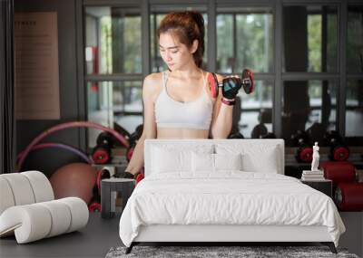 Beautiful asian woman is doing exercise in the gym Wall mural