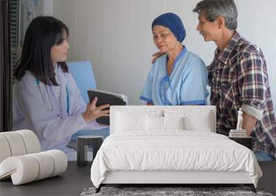 Cancer patient woman wearing head scarf after chemotherapy consulting and visiting doctor in hospital.... Wall mural