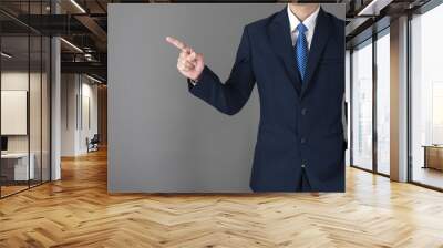 close up of business man in blue suit is pointing something on gray background Wall mural