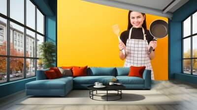 Happy female cook portrait on yellow background Wall mural