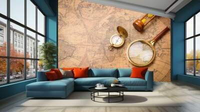 Old compass , magnifying glass and sand clock  on vintage map Wall mural