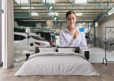 Portrait of young beautiful caucasian woman smiling in auto repair shop . concept of auto repair and maintenance service. Wall mural