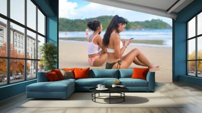 Young Beautiful woman in Bikini listening to music and using smartphone on the beach,  Summer, vacation, holidays, Lifestyles concept. Wall mural