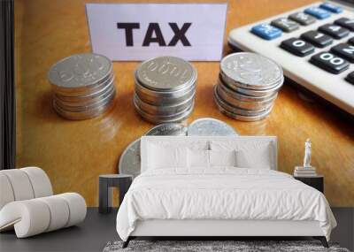 Tax payment concept. Money coins and calculator with text 'Tax' on the table. Wall mural