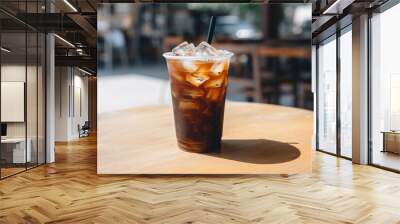 A black iced coffee on the table at a coffee shop. Wall mural